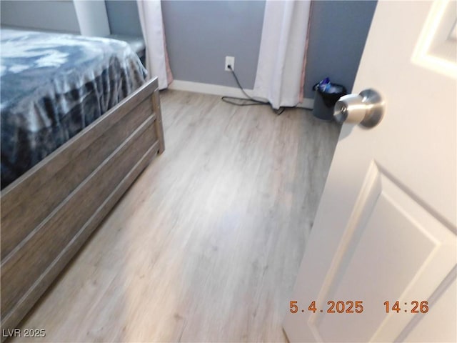 bedroom featuring baseboards and wood finished floors