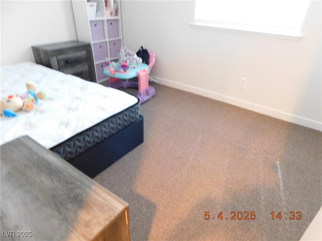 bedroom with baseboards and carpet