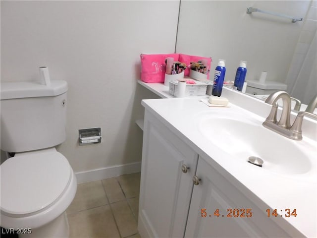 bathroom featuring toilet, baseboards, tile patterned flooring, and vanity