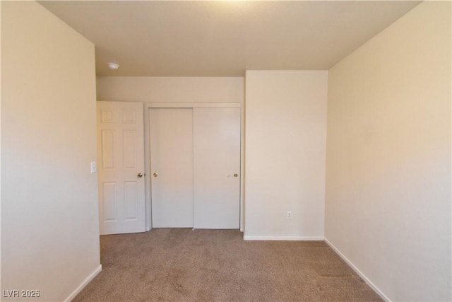 unfurnished bedroom featuring a closet, carpet flooring, and baseboards