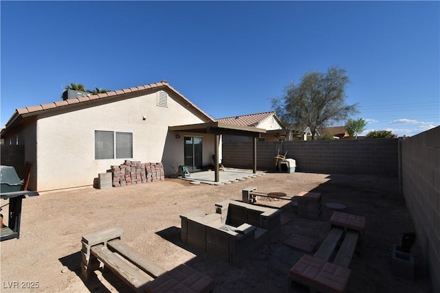 rear view of house with a patio, a fenced backyard, and stucco siding