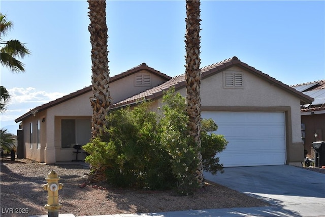 view of front of house with stucco siding, a tiled roof, and concrete driveway