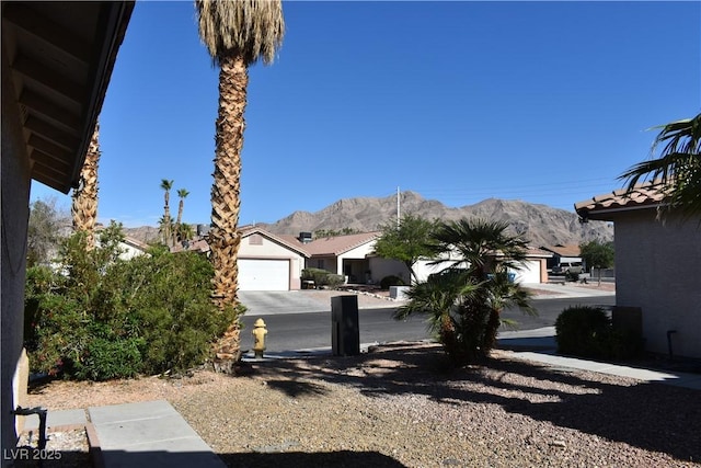 exterior space featuring a garage, a mountain view, and driveway