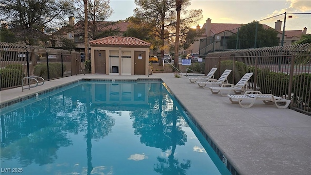 community pool with fence and a patio area