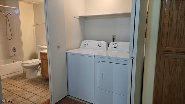 clothes washing area featuring washing machine and clothes dryer, laundry area, and light tile patterned floors