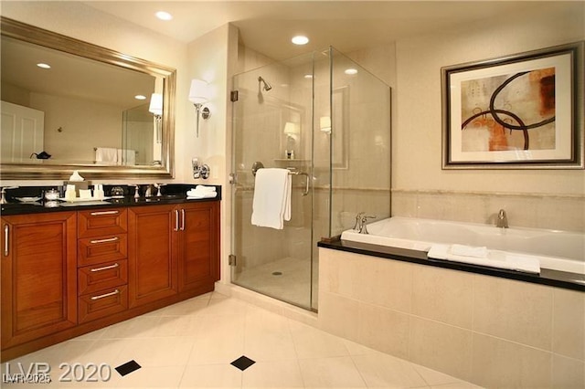 bathroom with tile patterned flooring, double vanity, a bath, and a stall shower