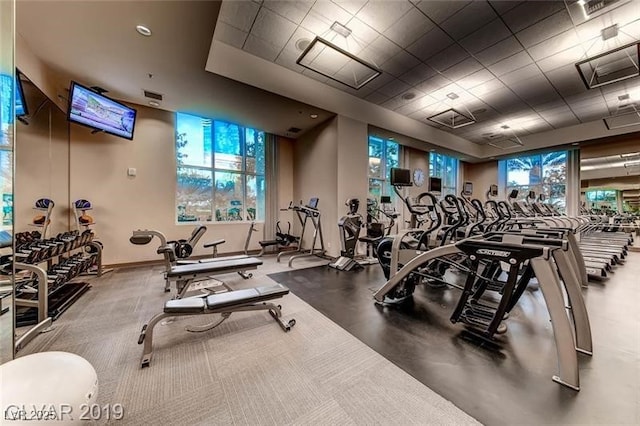 workout area with baseboards, visible vents, and a paneled ceiling