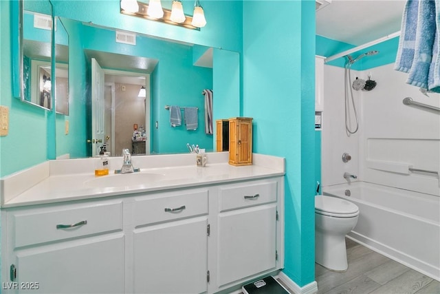 bathroom featuring toilet, visible vents, wood finished floors, and vanity