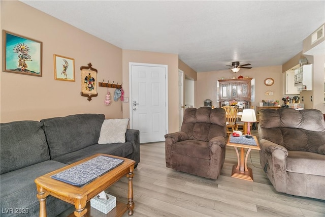living area featuring ceiling fan and light wood finished floors