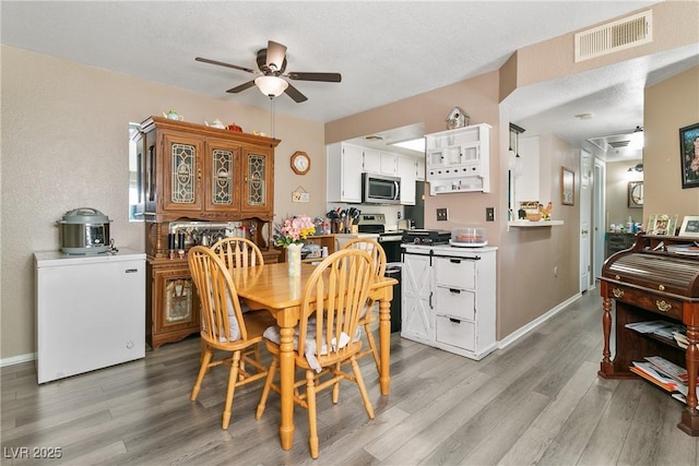 dining room with ceiling fan, visible vents, baseboards, and light wood-style floors