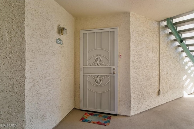 doorway to property featuring stucco siding