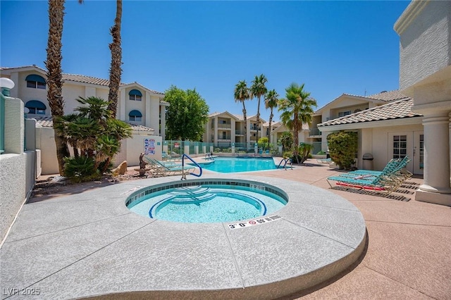 pool featuring fence, a hot tub, a patio area, and a residential view