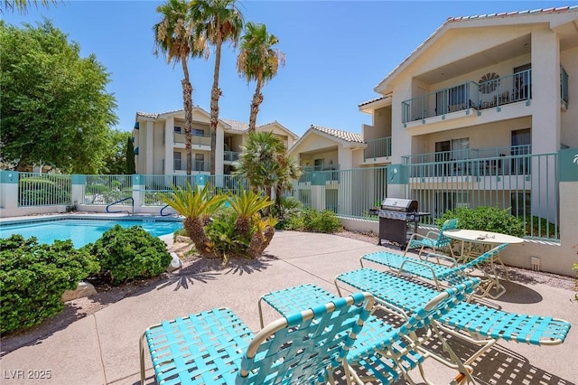 view of patio / terrace featuring fence, a community pool, and grilling area
