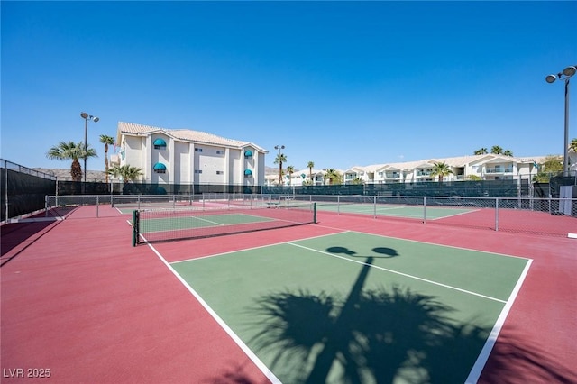 view of sport court with community basketball court, fence, and a residential view