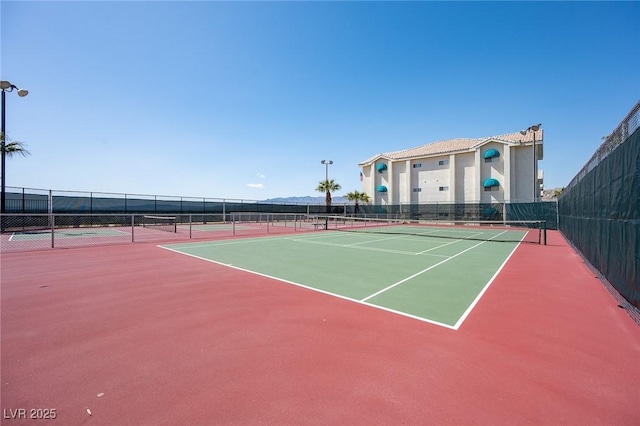 view of tennis court with fence and community basketball court