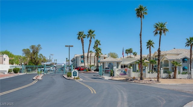 view of road with a residential view, a gate, a gated entry, and curbs