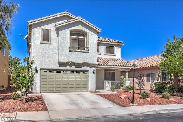 view of front of property with an attached garage, driveway, a tile roof, and stucco siding
