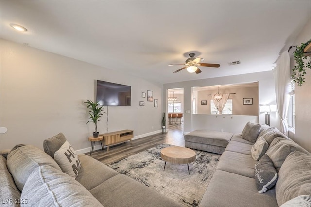 living area with visible vents, baseboards, ceiling fan, and wood finished floors