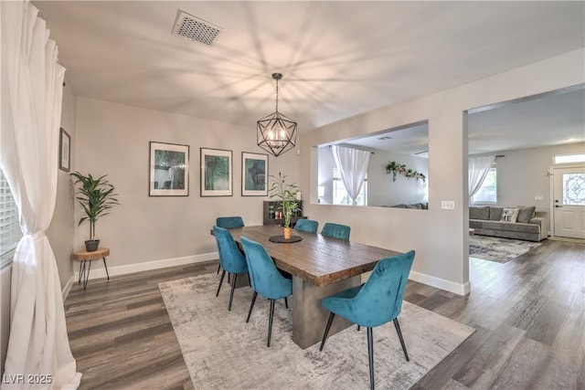 dining room with visible vents, baseboards, a notable chandelier, and dark wood-style floors