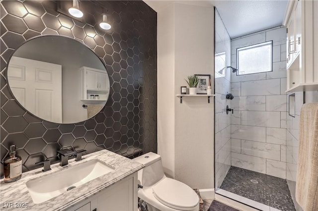 bathroom featuring toilet, decorative backsplash, tiled shower, and vanity