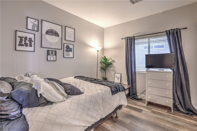 bedroom featuring visible vents and wood finished floors