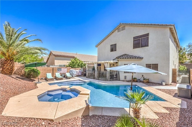 view of swimming pool with a patio, a pool with connected hot tub, and fence