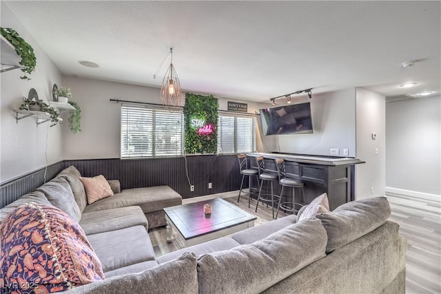 living room with a dry bar and wood finished floors