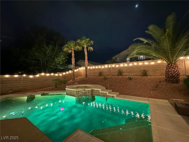 pool at night featuring a fenced backyard, a fenced in pool, and an in ground hot tub