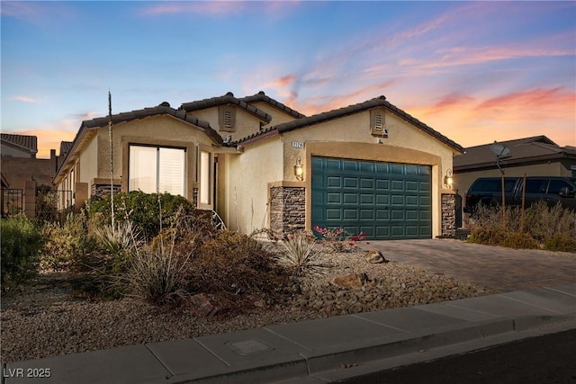 view of front of home featuring a garage, stucco siding, driveway, and a tiled roof