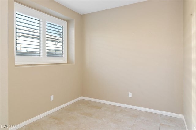 spare room featuring baseboards and light tile patterned floors