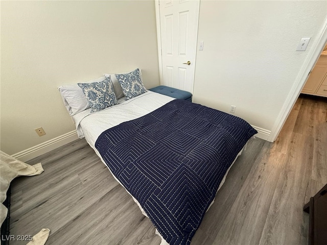 bedroom with baseboards and wood finished floors