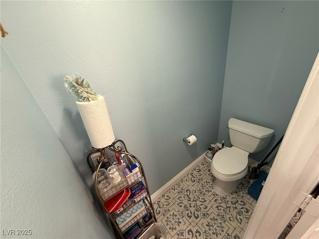 bathroom featuring baseboards and toilet