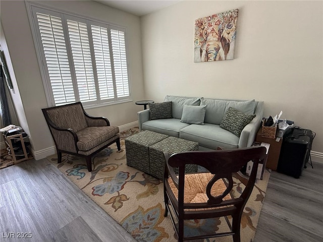 living area with baseboards and wood finished floors