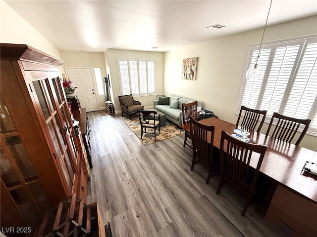 dining space featuring visible vents and wood finished floors