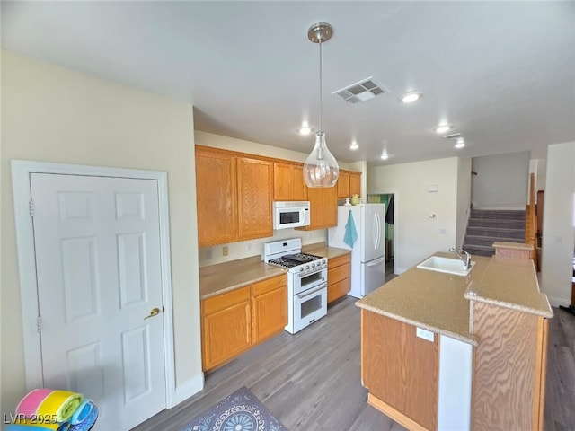 10071 Lemon Valley Ave, Las Vegas, NV 89147 - kitchen with white appliances, a sink, wood finished floors, a center island with sink, and pendant lighting
