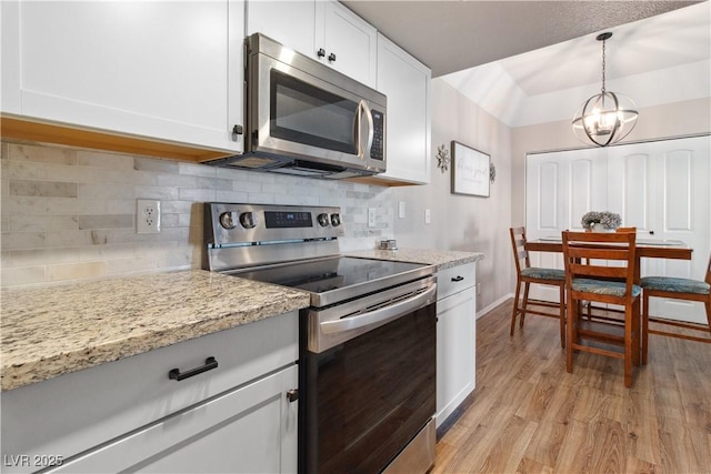 3550 Bay Sands Dr Unit 2101, Laughlin, NV 89029 - kitchen with white cabinets, appliances with stainless steel finishes, light wood finished floors, a chandelier, and tasteful backsplash