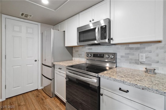 3550 Bay Sands Dr Unit 2101, Laughlin, NV 89029 - kitchen with decorative backsplash, visible vents, white cabinetry, stainless steel appliances, and light wood-style flooring