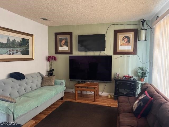 living area featuring a textured ceiling and wood finished floors