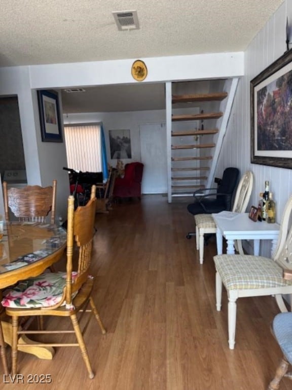 sitting room with a textured ceiling, wood finished floors, and visible vents
