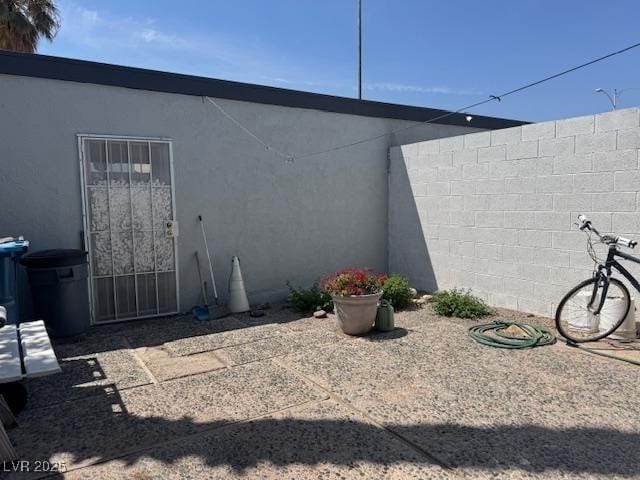 view of side of property with stucco siding and fence