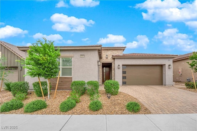 view of front of property featuring an attached garage, decorative driveway, and stucco siding