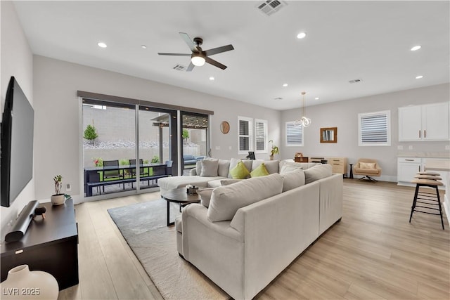 living room with ceiling fan, recessed lighting, light wood-style flooring, and visible vents