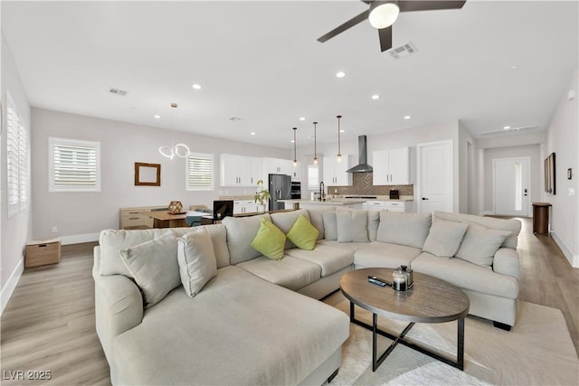 living room with recessed lighting, baseboards, and light wood finished floors