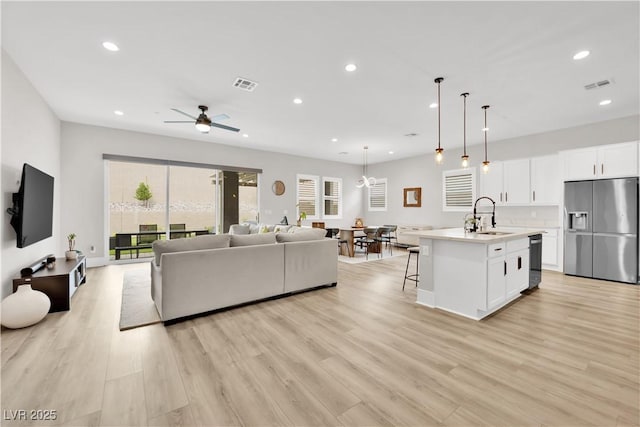 living room with recessed lighting, ceiling fan, visible vents, and light wood finished floors