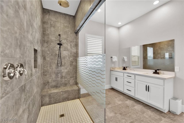 full bathroom featuring double vanity, a sink, walk in shower, and tile patterned flooring