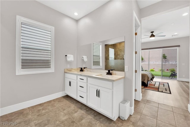 bathroom featuring a sink, double vanity, tile patterned floors, a ceiling fan, and baseboards