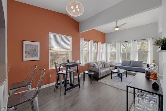 living room with a ceiling fan, a healthy amount of sunlight, wood finished floors, and lofted ceiling
