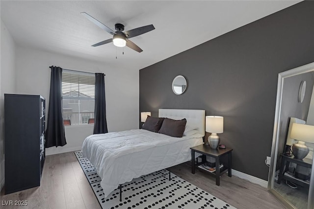bedroom featuring baseboards, ceiling fan, and wood finished floors