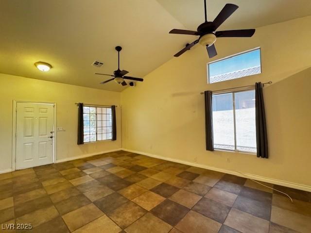 unfurnished room featuring ceiling fan, visible vents, baseboards, and high vaulted ceiling