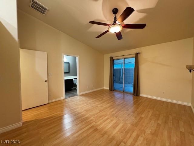 spare room featuring light wood finished floors, a ceiling fan, baseboards, lofted ceiling, and visible vents